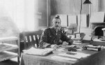 Informal portrait of Brigadier General C B B White, of 1st Anzac Corps Headquarters, in his office, at the Chateau of Henencourt, 31 July 1917